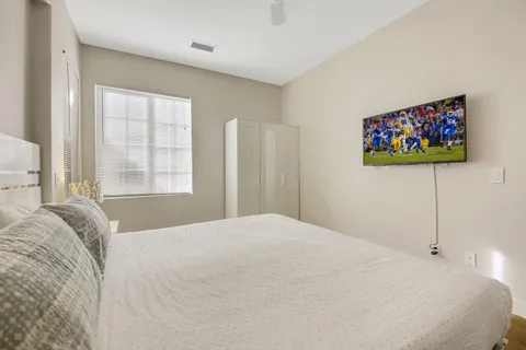 a bedroom with a bed and a flat screen tv