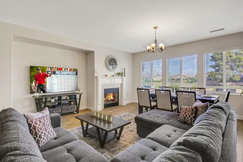 a living room with furniture fireplace and a large window