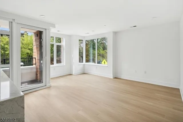a view of an empty room with glass door and balcony