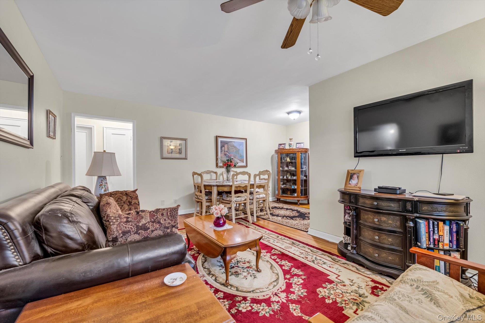 69-18 Bell Boulevard, Unit B Queens, NY 11364 - Photo 4 of 9 a living room with furniture and a flat screen tv