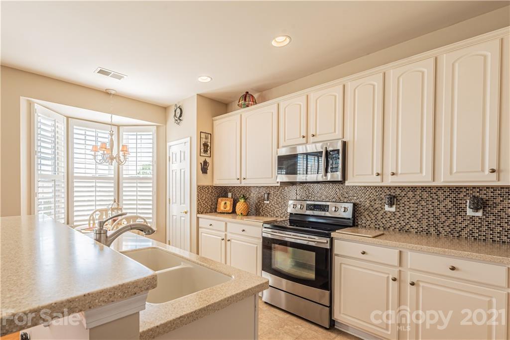 279 Garnet Court, Unit 549 Fort Mill, SC 29708 - Photo 14 of 47 a kitchen with stainless steel appliances granite countertop a sink a stove and cabinets