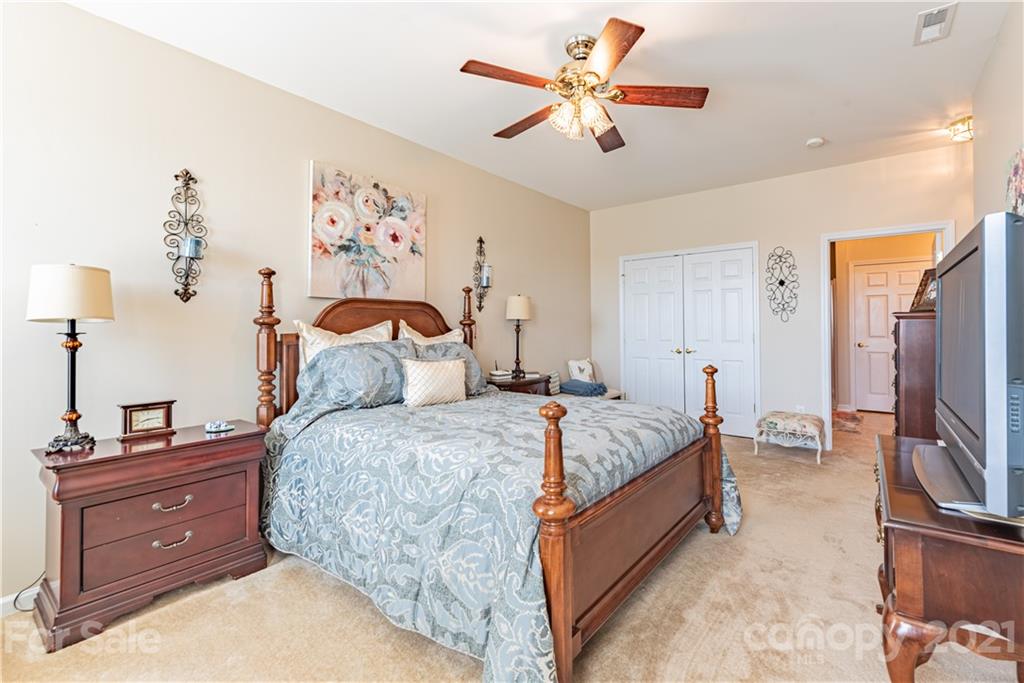 279 Garnet Court, Unit 549 Fort Mill, SC 29708 - Photo 22 of 47 a bed room with a bed and a flat tv screen on dresser