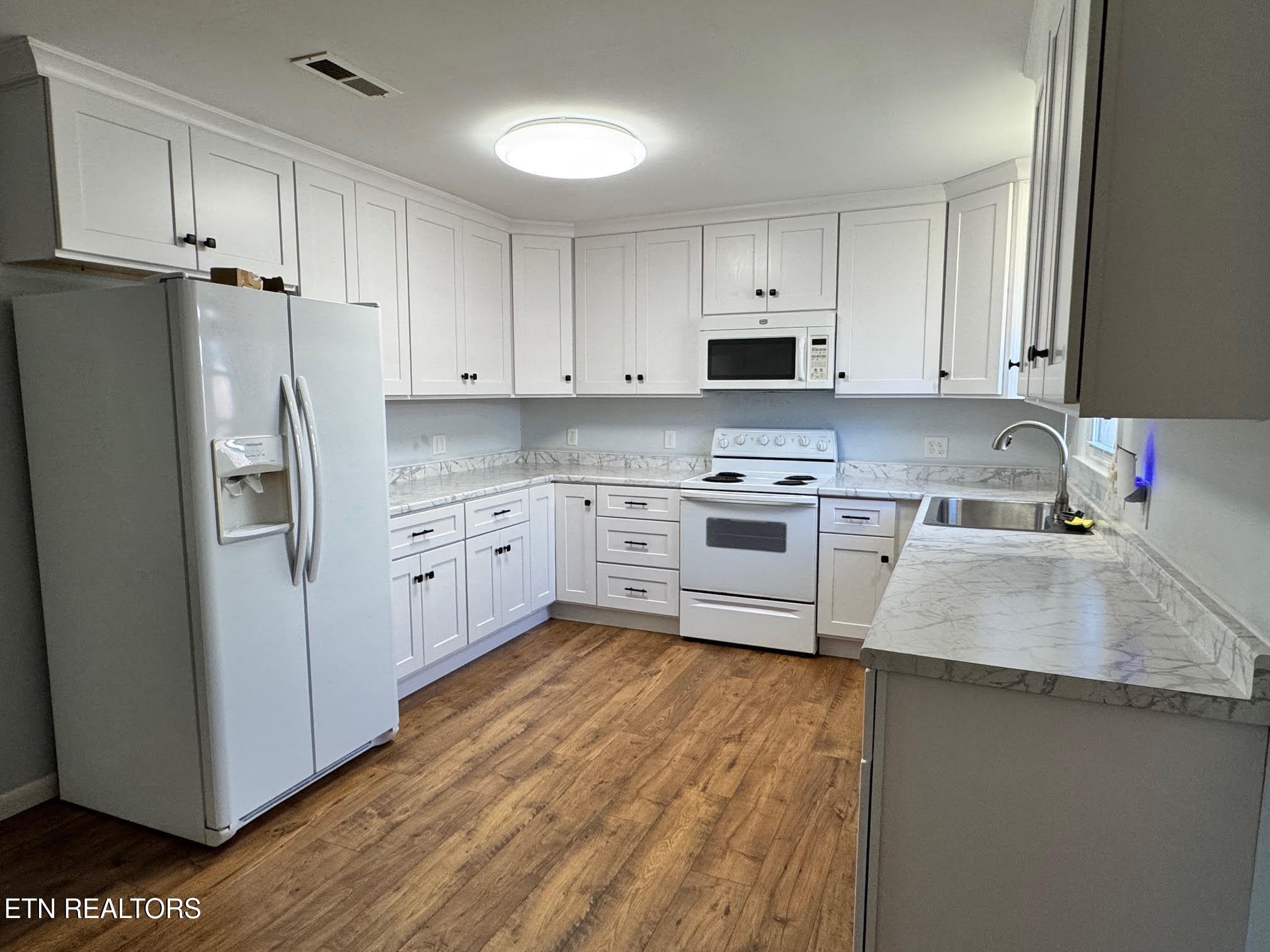34 Hampton Square Crossville, TN 38555 - Photo 7 of 30 a kitchen with white cabinets and stainless steel appliances