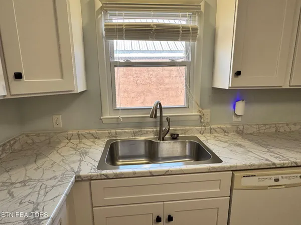a kitchen with granite countertop a sink and cabinets