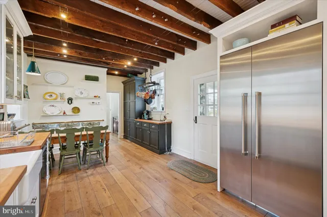 a kitchen with stainless steel appliances granite countertop a refrigerator and table chairs