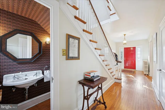a view of a hallway with wooden floor and stairs