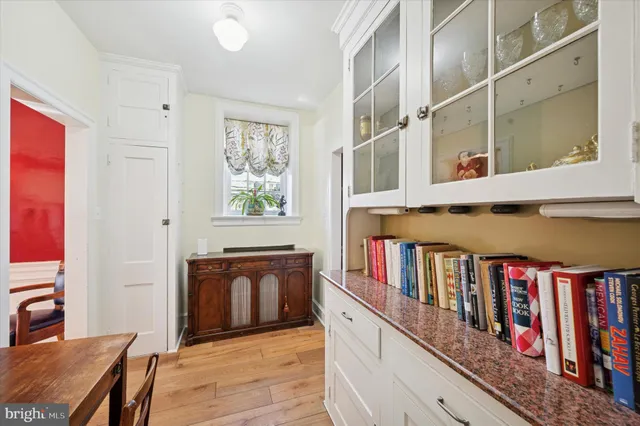 a view of front door with entryway and wooden floor