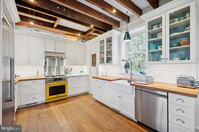 a kitchen with stainless steel appliances granite countertop a sink and cabinets with wooden floors