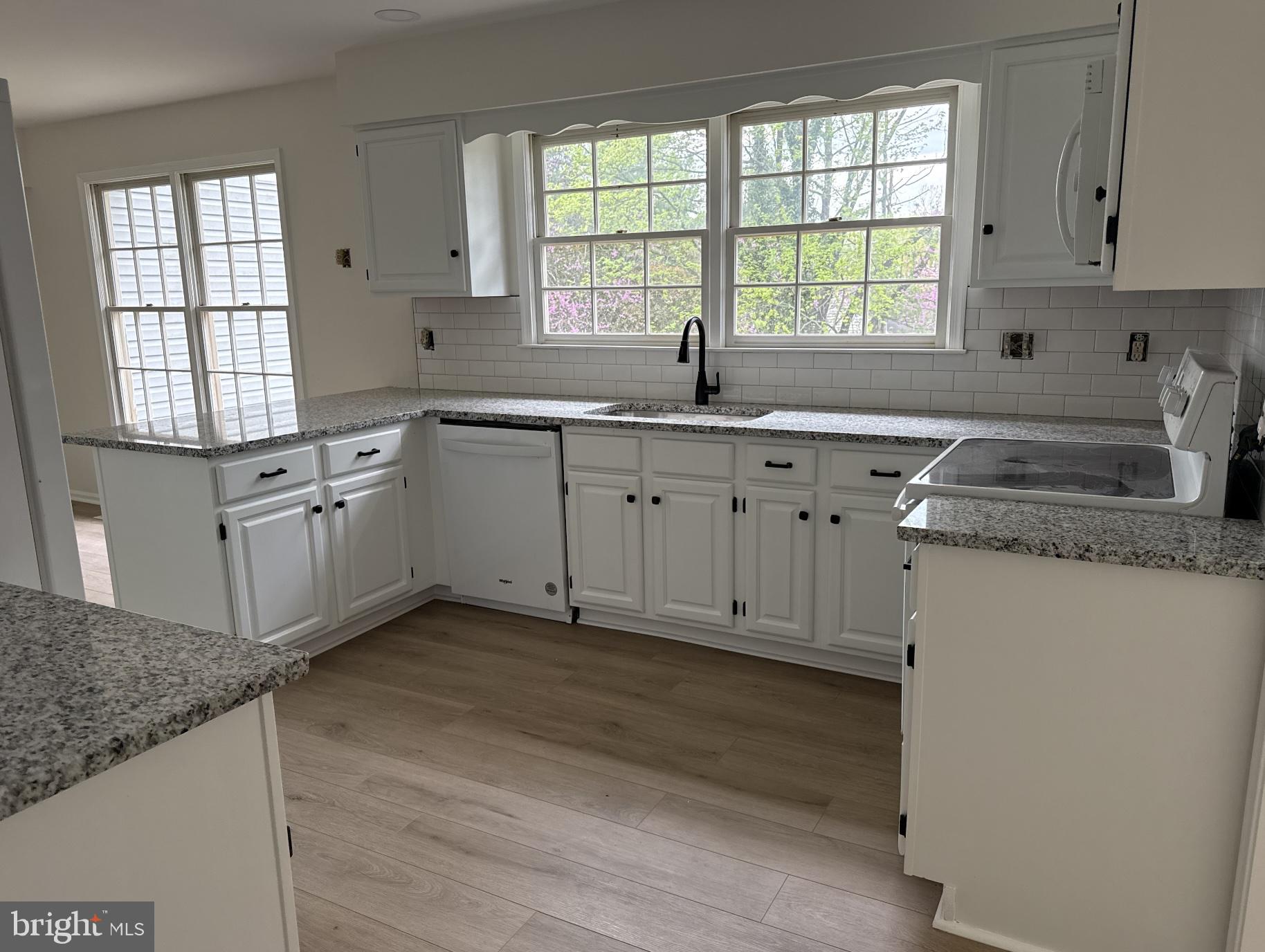 213 Primavera Circle Sterling, VA 20165 - Photo 2 of 2 a kitchen with granite countertop white cabinets sink and window stainless steel appliances