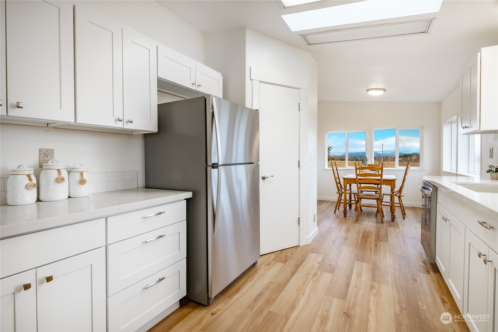 6671 Olson Road Ferndale, WA 98248 - Photo 10 of 40 a kitchen with stainless steel appliances granite countertop refrigerator cabinets dining table and chairs