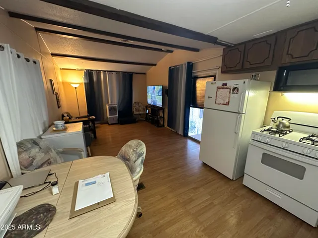 a living room with furniture and a refrigerator