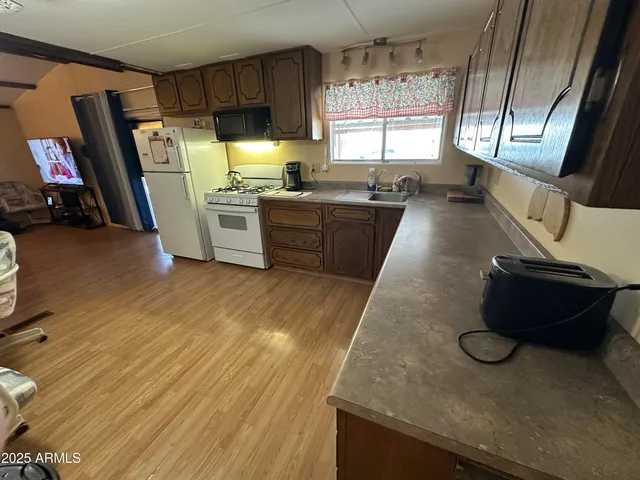 a kitchen with sink refrigerator and window