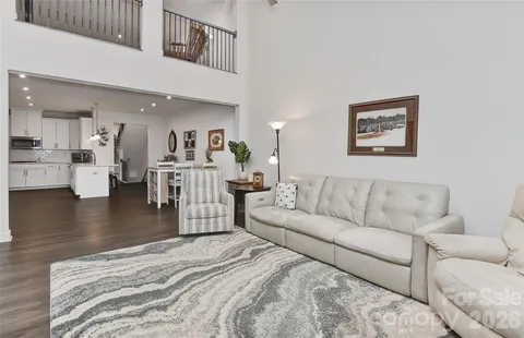 a living room with furniture and a view of kitchen