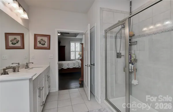 a en suite bathroom with a double vanity sink a mirror and a shower