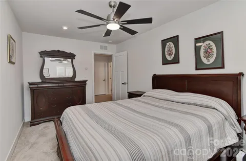 a bedroom with a bed and painting on the wall