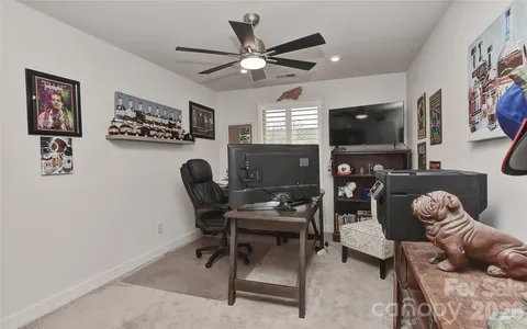 a work room with furniture a flat screen tv and a window
