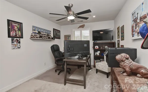 a work room with furniture a flat screen tv and a window