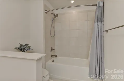 a bathroom with a shower a toilet and a sink