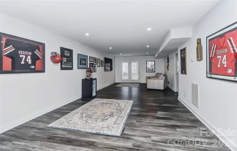a view of a hallway with wooden floor and living room