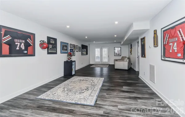 a view of a hallway with wooden floor and living room
