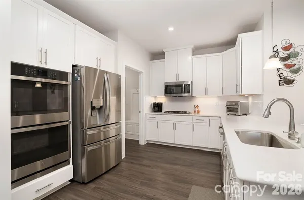 a kitchen with stainless steel appliances a refrigerator sink and microwave
