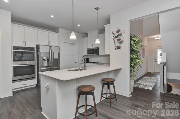 a kitchen with stainless steel appliances kitchen island a refrigerator and a stove top oven