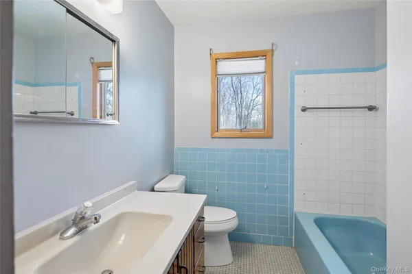 a bathroom with a sink a toilet and mirror