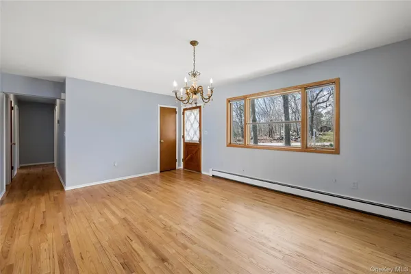 a view of a room with wooden floor and chandelier