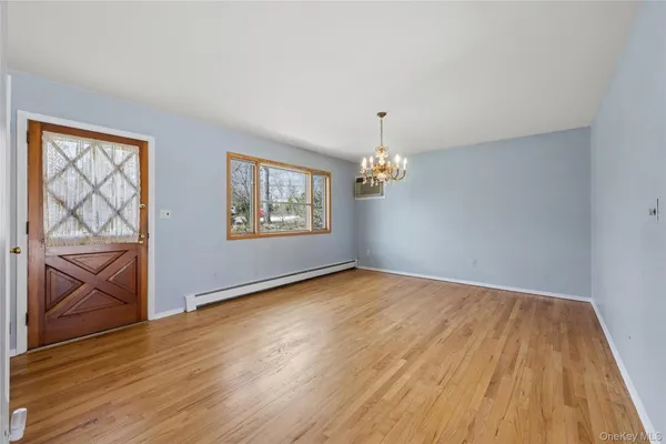 a view of empty room with window and chandelier fan
