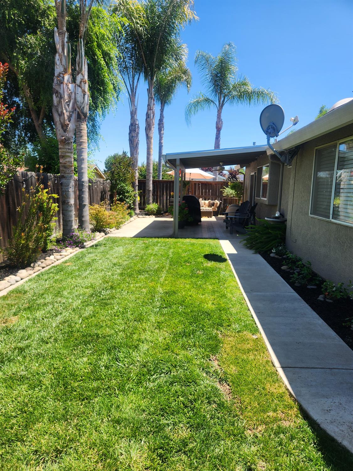 777 Jordanolo Drive Ripon, CA 95366 - Photo 44 of 61 a view of a yard with table and chairs under an umbrella