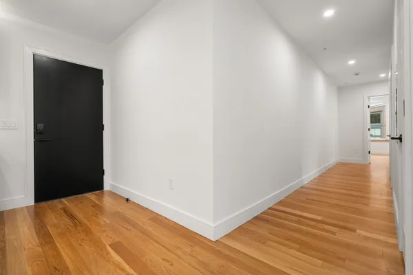 a view of an empty room with wooden floor