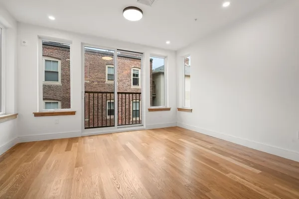 a view of a room with wooden floor and windows