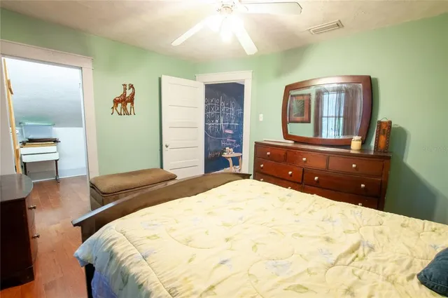 a bedroom with a bed and wooden floor