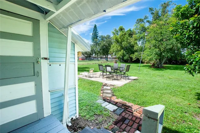 a view of backyard with outdoor seating and green space
