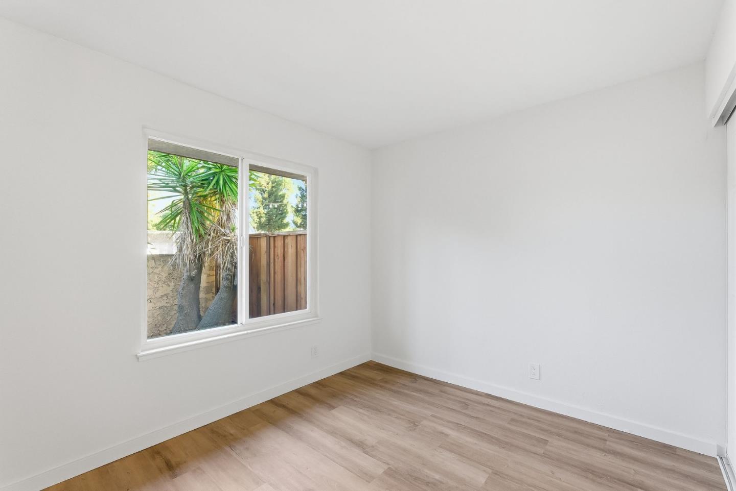 7147 Rouse Court San Jose, CA 95139 - Photo 18 of 36 an empty room with wooden floor and windows