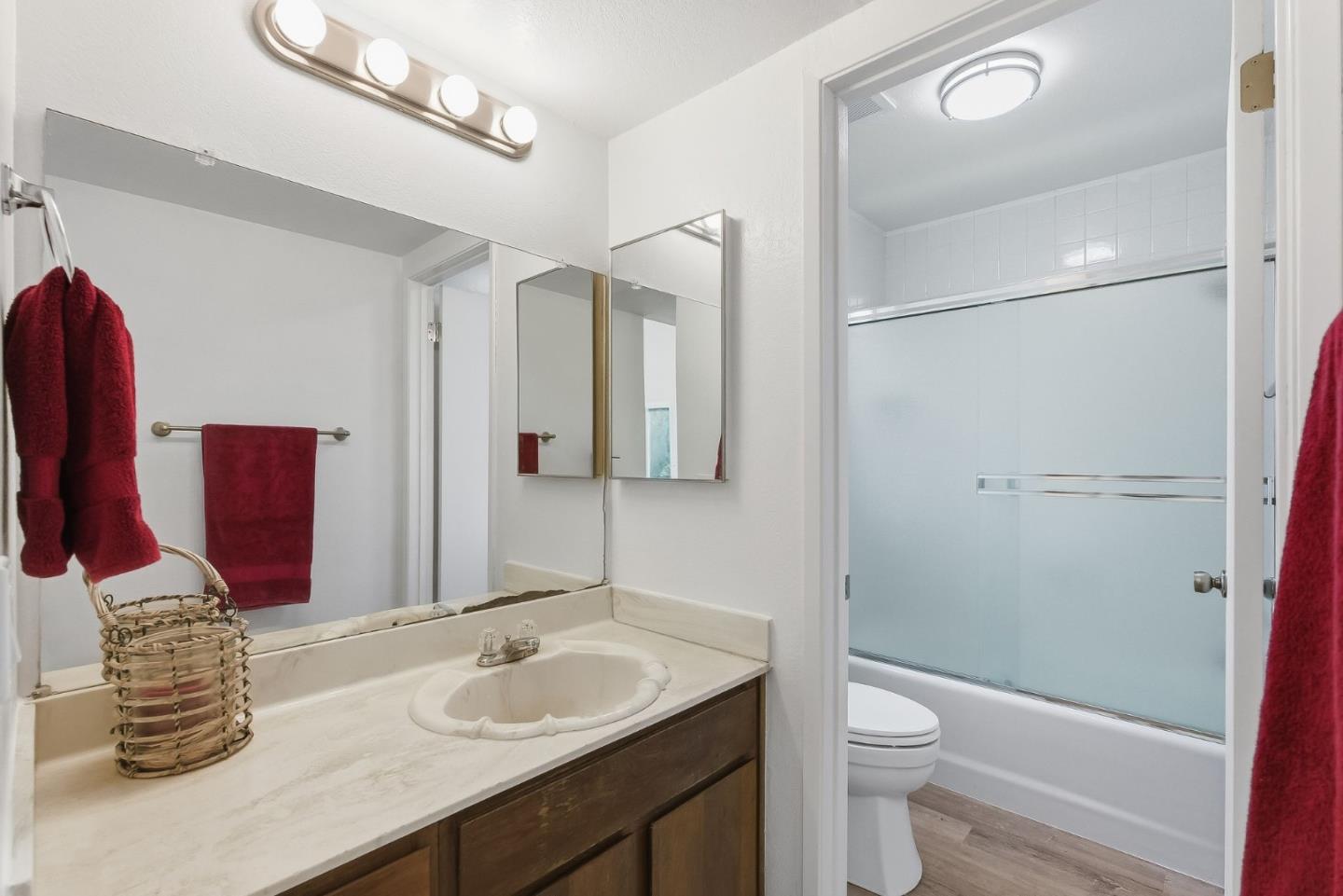 7147 Rouse Court San Jose, CA 95139 - Photo 25 of 36 a bathroom with a granite countertop sink a toilet a mirror and shower