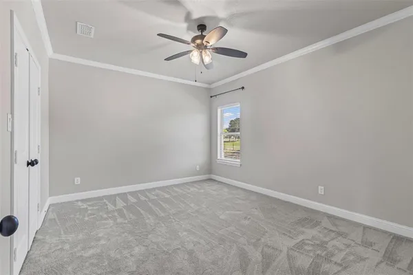 an empty room with window and ceiling fan