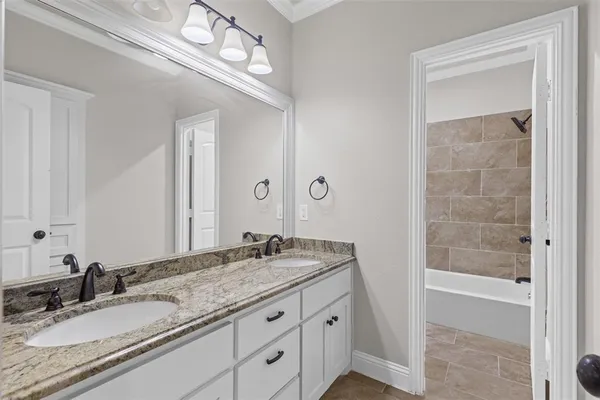 a bathroom with a granite countertop sink a light fixture and a mirror