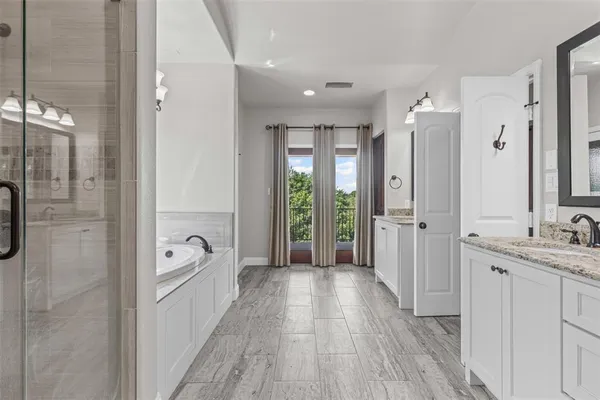 a bathroom with a tub shower vanity and a sink