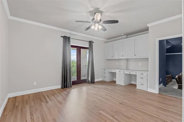 a view of a kitchen with wooden floor and a ceiling fan