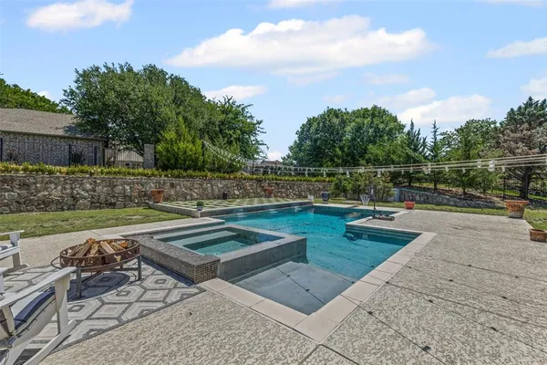 a view of swimming pool with seating space and wooden fence