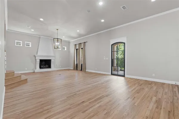 an empty room with wooden floor and fireplace