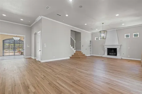 an empty room with wooden floor and fireplace