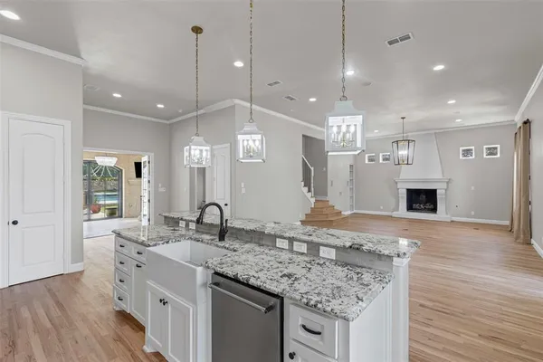a large kitchen with granite countertop a large kitchen island in the center