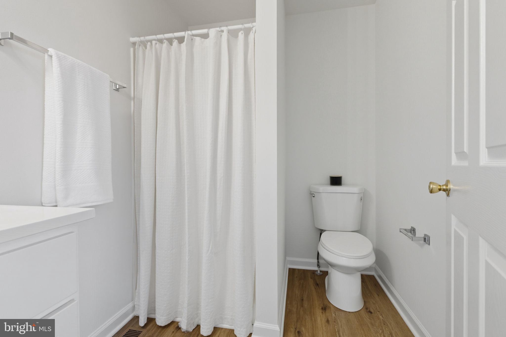 55 Fuzzy Tail Drive Ranson, WV 25438 - Photo 24 of 61 a white toilet sitting next to a shower curtain