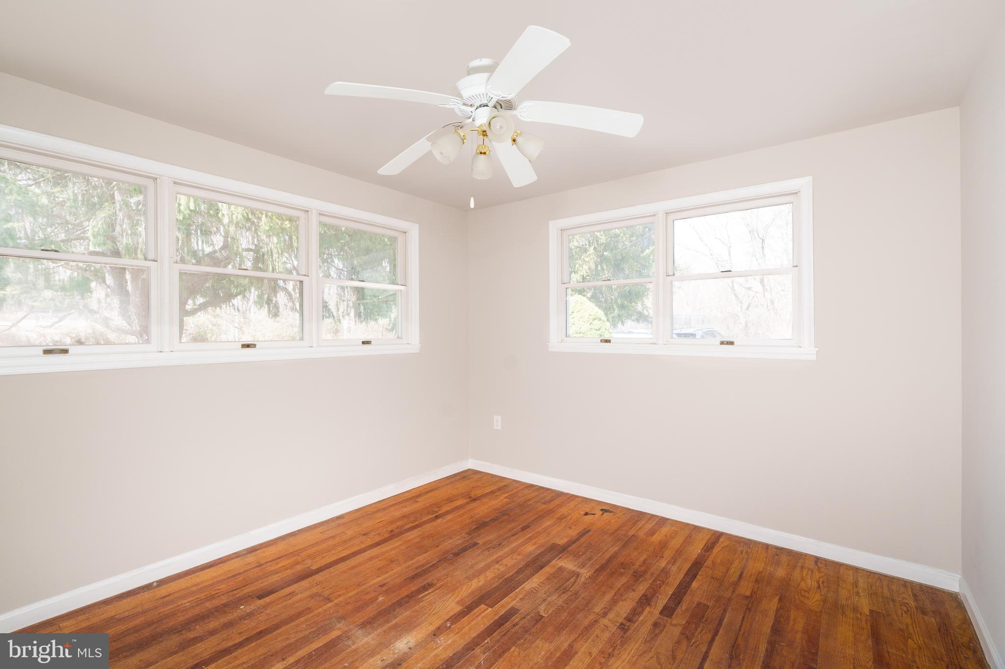 264 Union Church Road Elkton, MD 21921 - Photo 8 of 12 an empty room with wooden floor fan and windows