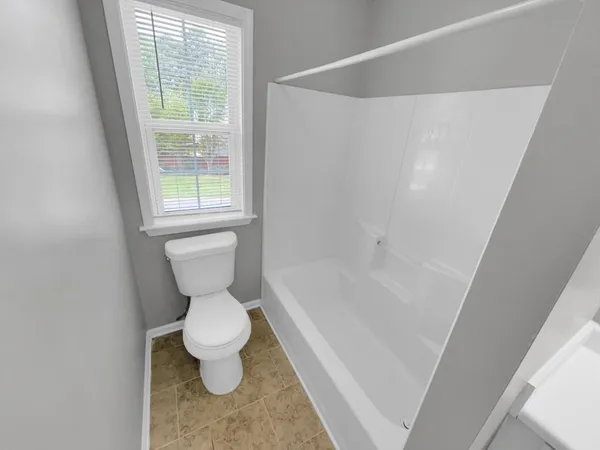 a white toilet sitting next to a bath tub