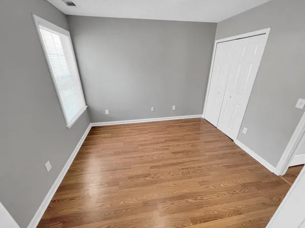an empty room with wooden floor and stairs