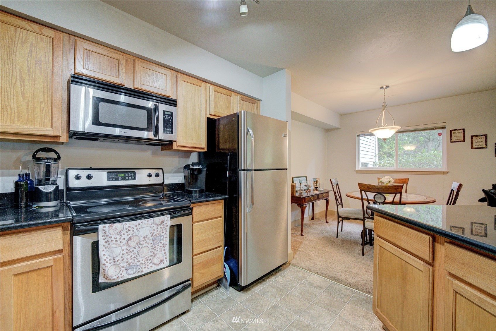 5809 Hwy Place, Unit B103 Everett, WA 98203 - Photo 17 of 30 a kitchen with stainless steel appliances granite countertop a stove a sink and a microwave