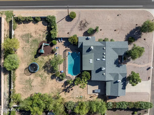 an aerial view of a house with a yard and a wooden deck